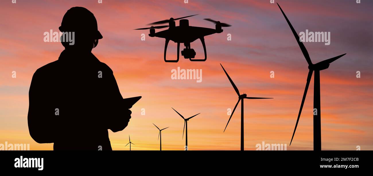 Silhouette d'ingénieur avec ordinateur tablette, drone et éoliennes au coucher du soleil Banque D'Images