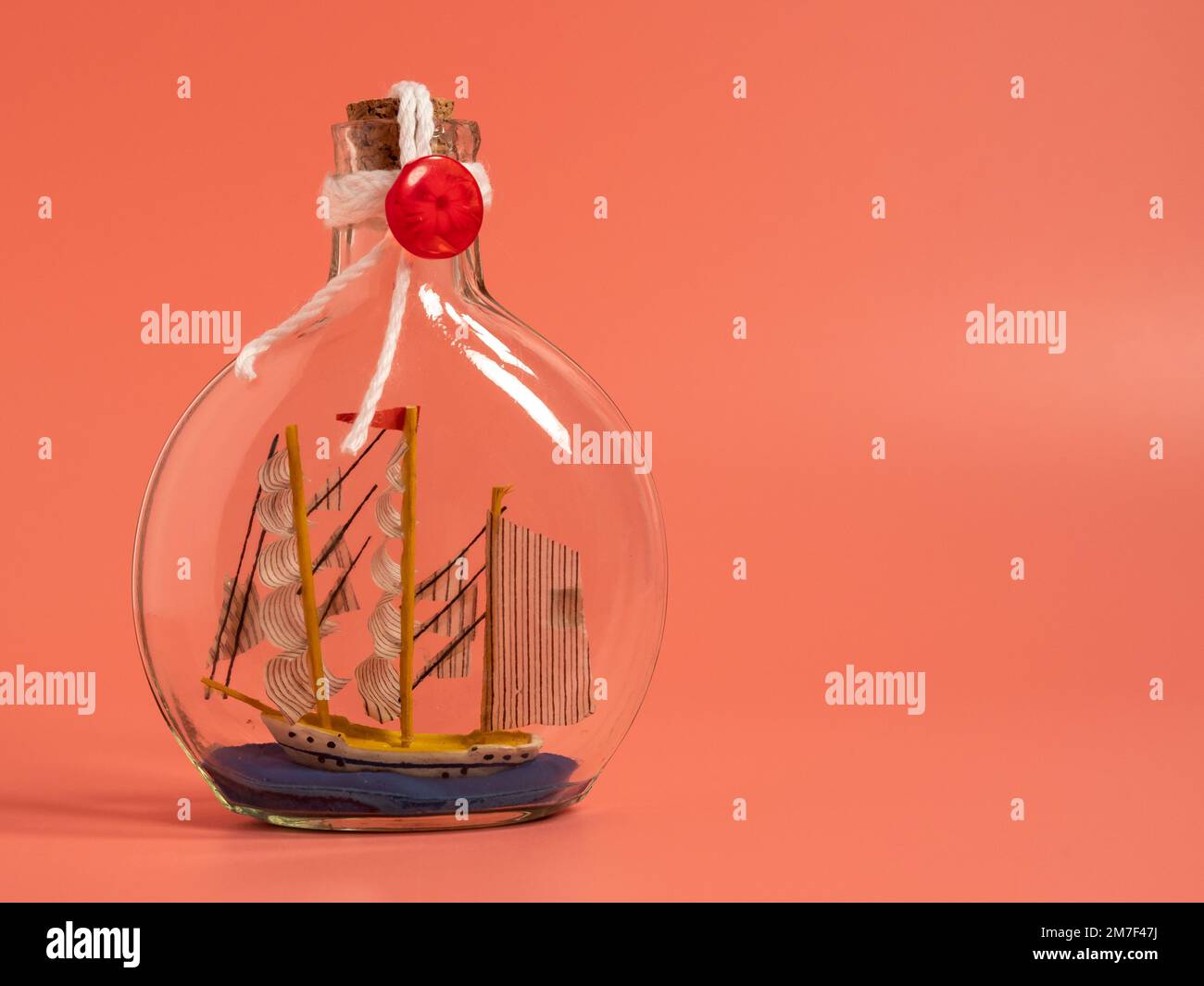 Expédier dans une bouteille sur fond rose. Gros plan. Banque D'Images