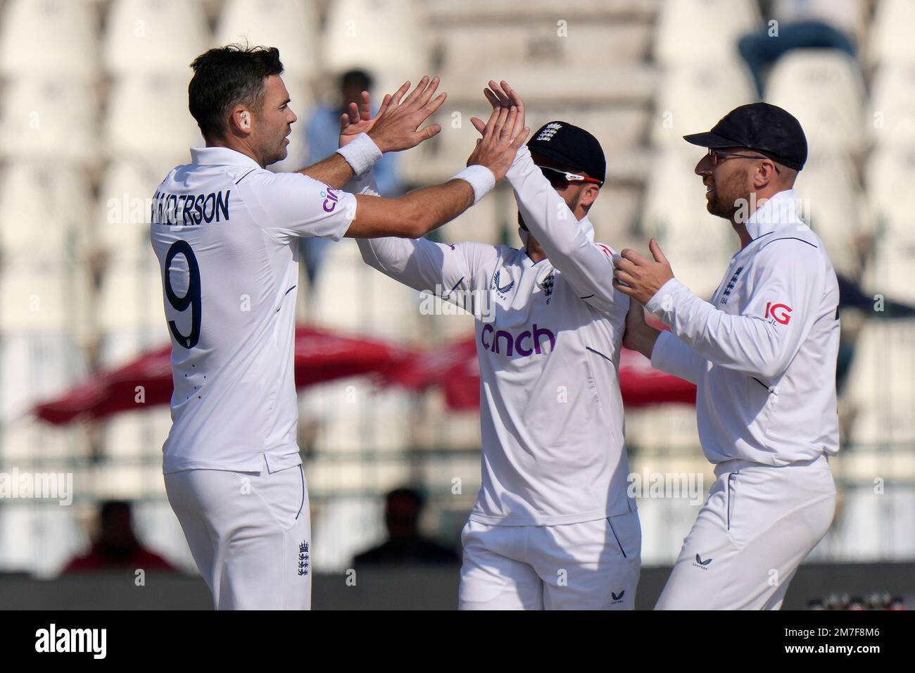 England's James Anderson, left, celebrates with teammates after taking the wicket of Pakistan's Abrar Ahmed during the fourth day of the second test cricket match between Pakistan and England, in Multan, Pakistan, Monday, Dec. 12, 2022. (AP Photo/Anjum Naveed) Banque D'Images