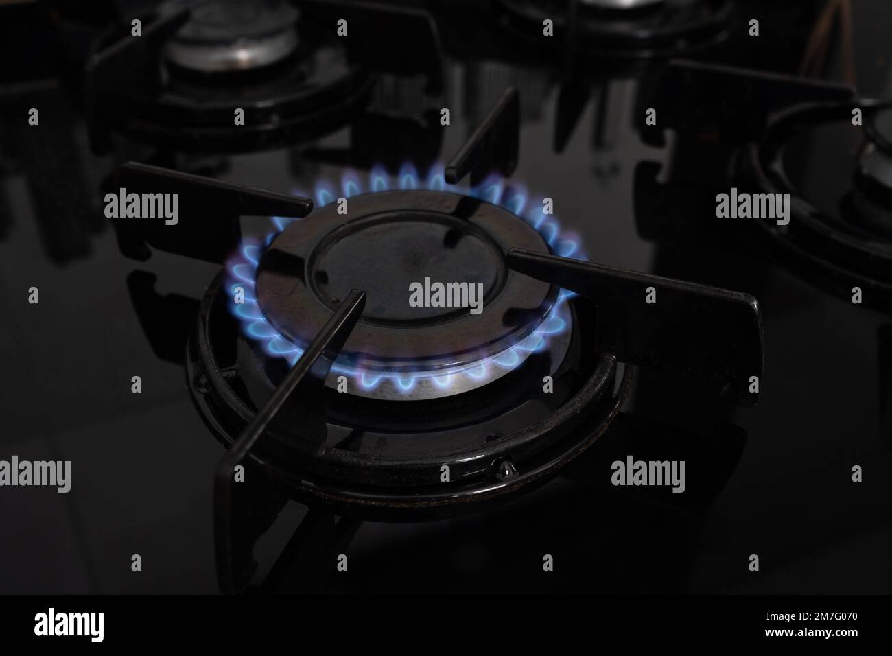 Cuisinière à gaz brûlant une flamme bleue. Anneau à gaz allumé sur une table de cuisson. Plaque de cuisson dans la cuisine. Banque D'Images