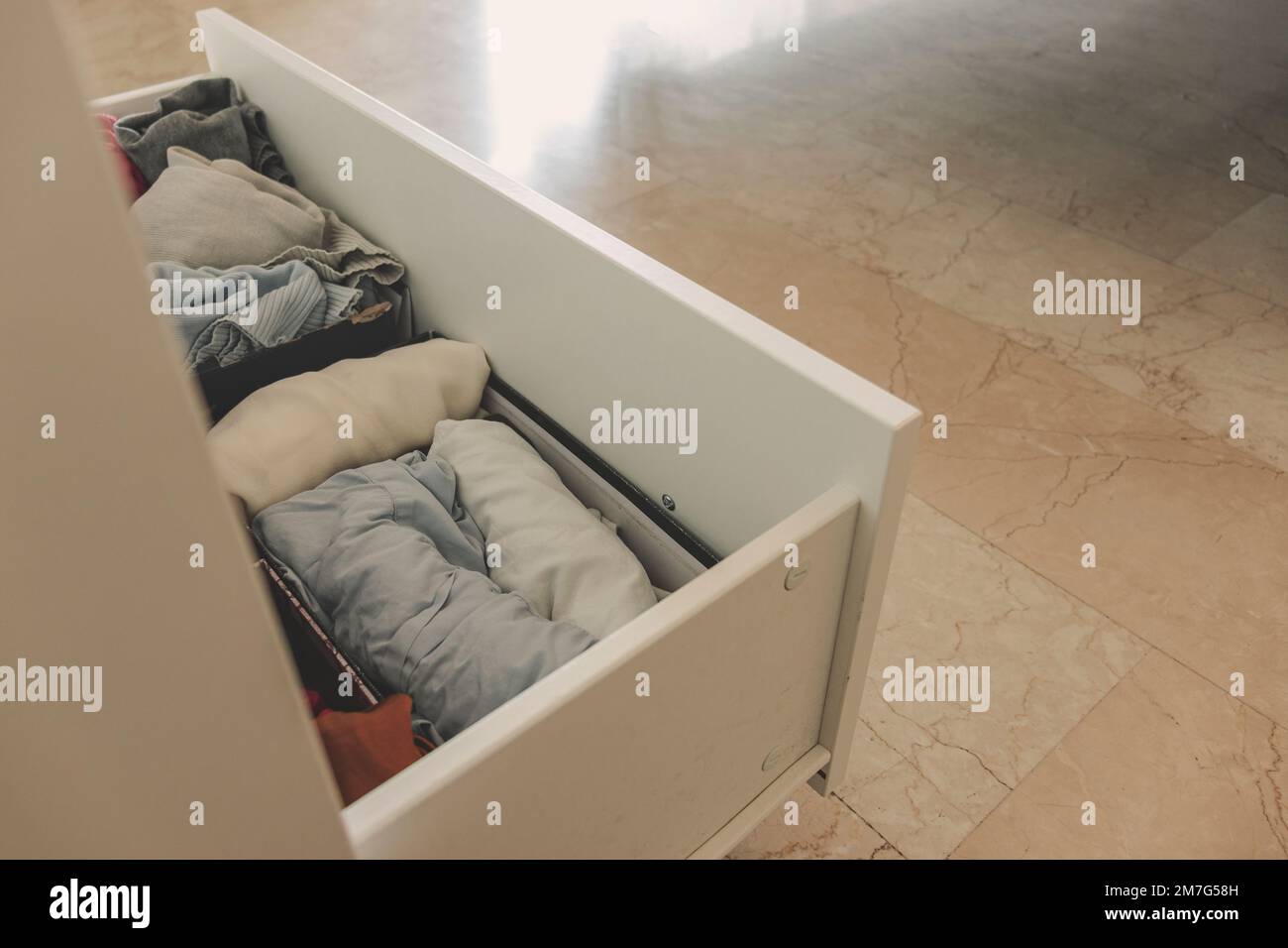 Vue en grand angle d'un tiroir avec des vêtements soigneusement pliés. Concept de minimalisme, de mess et de nettoyage de garde-robe. Banque D'Images