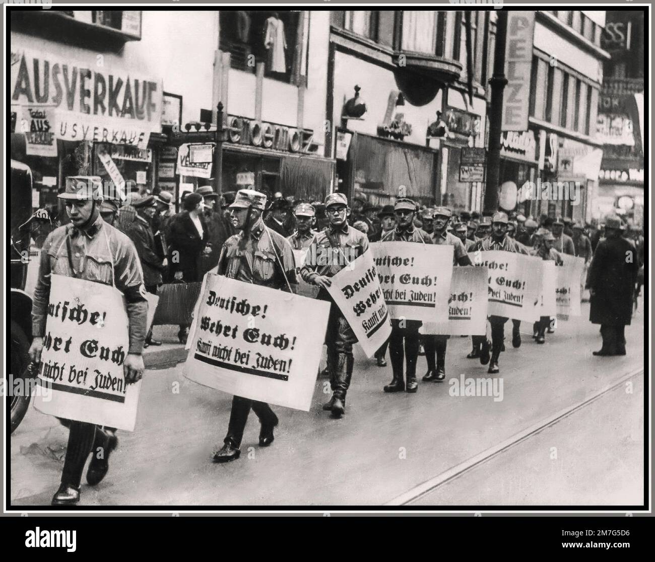 1930s Nazis Germany sa Sturmabteilung hommes marchent dans les rues commerçantes de Berlin portant des plaques contre les propriétaires juifs de magasins de détail de l'Allemagne, 1938 les plaques portées avec eux portent l'inscription «Allemands bagarre back! N'achetez pas auprès des Juifs!". La persécution des Juifs par le régime nazi a atteint son premier pic sur 9 novembre et 10th, 1938, sur ce qu'on appelle Kristallnacht. Banque D'Images
