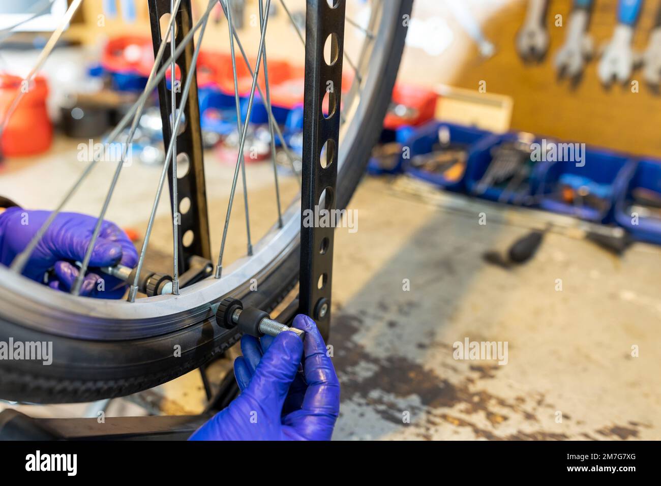 Technicien de cyclisme réparant et entretenant la moto et le sélecteur de vitesse en atelier Banque D'Images
