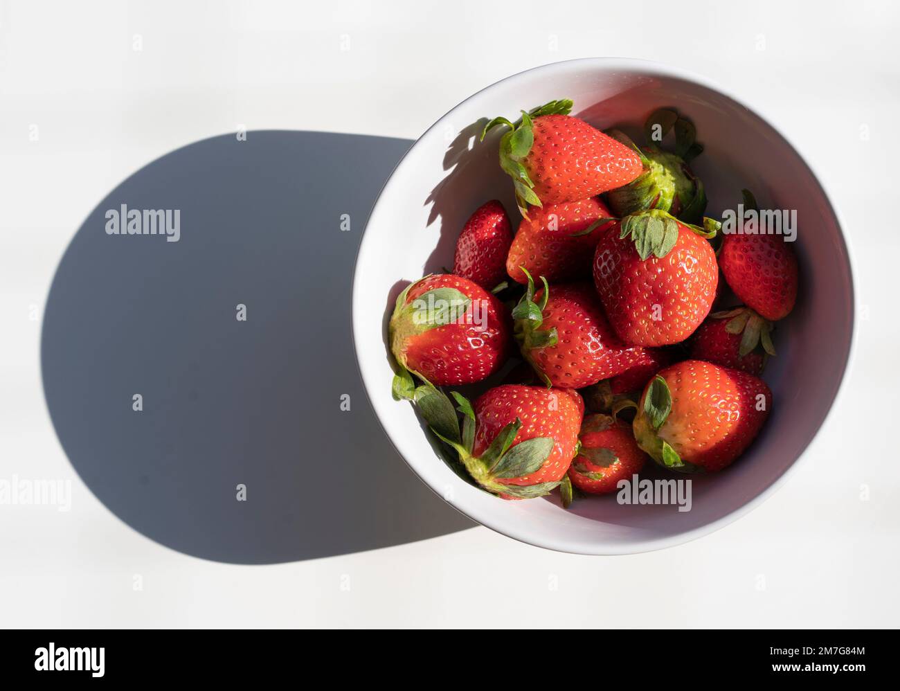 Vue de dessus des fraises fraîches dans un bol blanc isolé sur fond blanc Banque D'Images