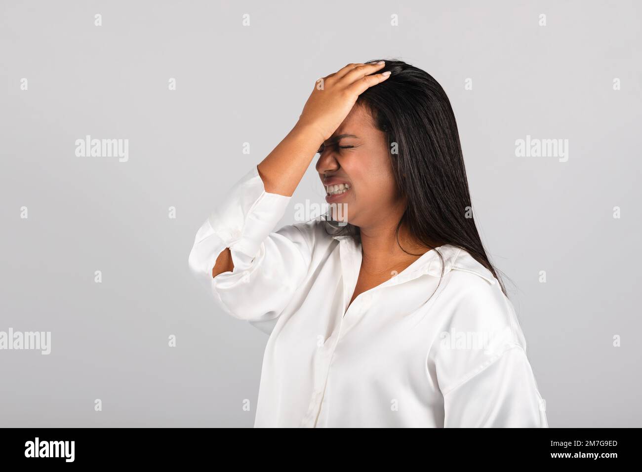 Une femme noire millénaire frustrée en blouse blanche appuie la main sur le front, souffrant de stress Banque D'Images