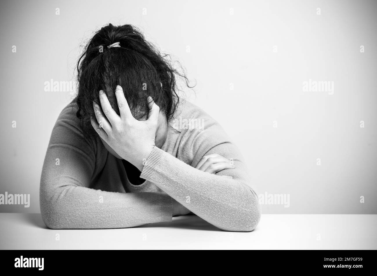 Femme sans-abri addicte de drogue et d'alcool assis seul et déprimé à la maison se sentant anxieux et solitaire, noir et blanc Banque D'Images