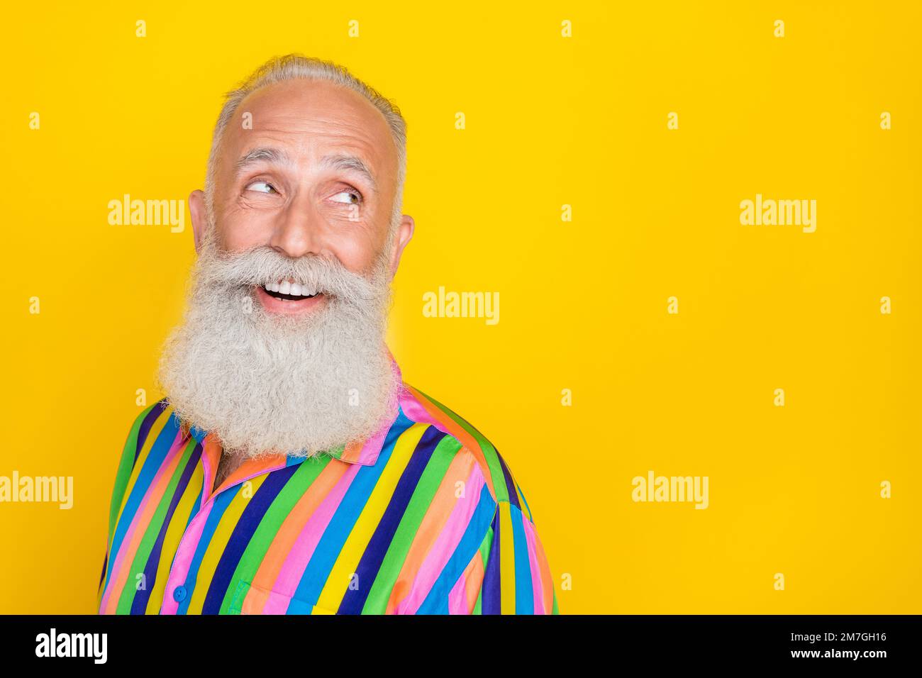 Portrait de satisfait optimiste beau vieux homme avec la longue barbe porter chemise colorée look vide espace isolé sur fond jaune couleur Banque D'Images