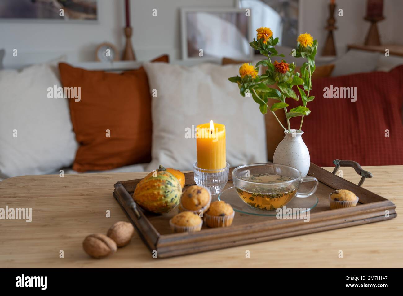 Plateau avec une tasse de thé, bougie éclairée et décoration d'automne sur une table dans le salon, maison confortable en saison froide, espace copie, sélection de foyer, narr Banque D'Images