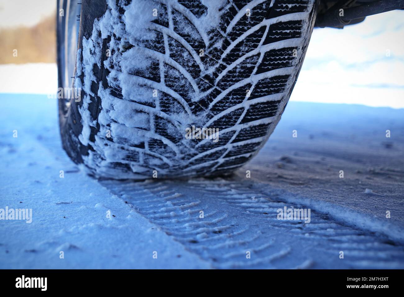 Conduite d'une voiture avec roue à pneus d'hiver sur route enneigée Banque D'Images