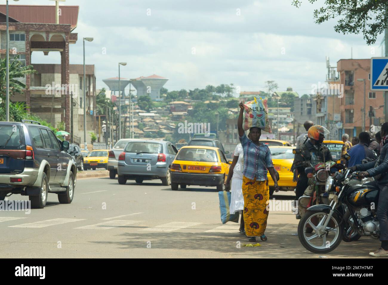 Femme portant un sac de marché sur son marchand principal dans les rues de Yaoundé au Cameroun pendant la journée Banque D'Images