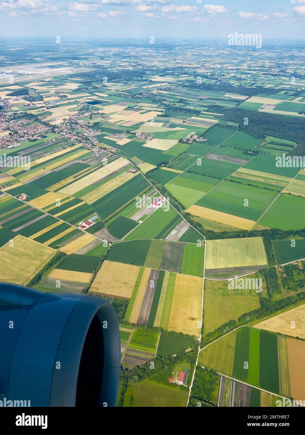 Admirez depuis le paysage ci-dessus autour de Munich, en Allemagne, comme vu par avion en juillet. La terre est luxuriante et les nuages dans le ciel donnent de la dimension aux champs et au village. Banque D'Images