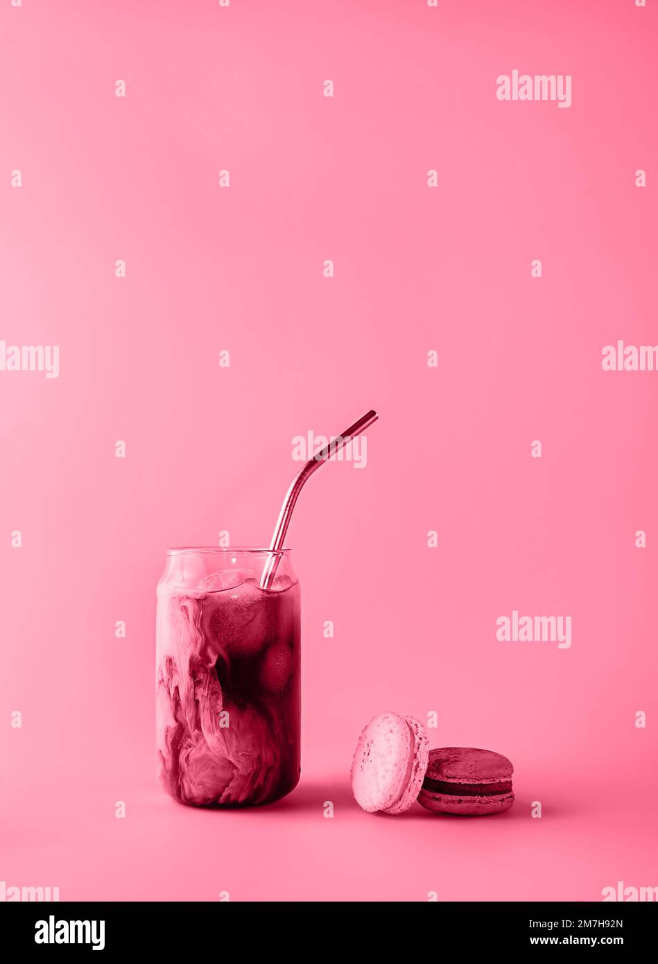 Verre de café glacé en grand verre à la crème et aux macarons, tons magenta tendance de l'année 2023. Concept alimentaire. Copier l'espace. Gros plan. Banque D'Images