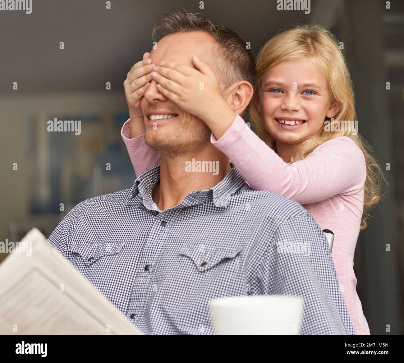 Ssshhh... ne soufflez pas ma couverture. une jeune fille surprend son père en couvrant ses mains sur ses yeux. Banque D'Images