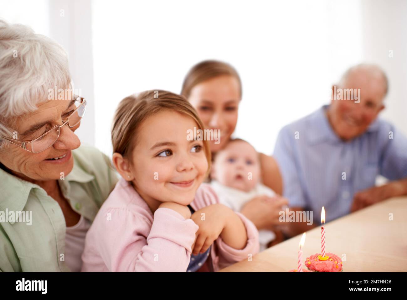 Je souhaite un poney. Portrait d'une famille heureuse de trois générations célébrant un anniversaire à la maison. Banque D'Images