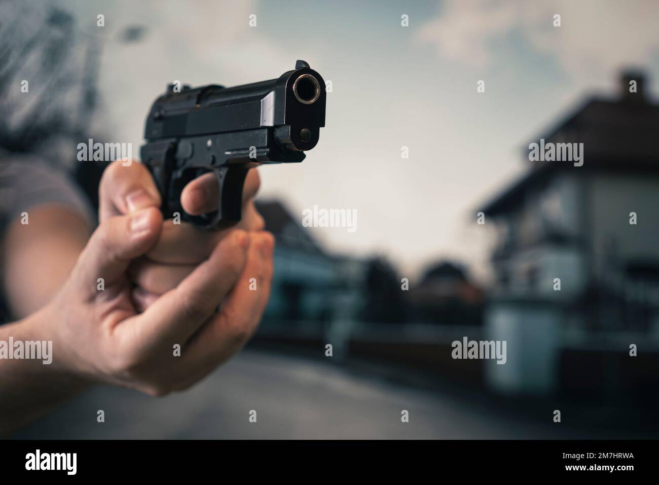 main d'homme tenant un pistolet de pointage avec un doigt sur la gâchette. concept de crime de rue. un homme croque dans la rue. Menace de mort. Banque D'Images