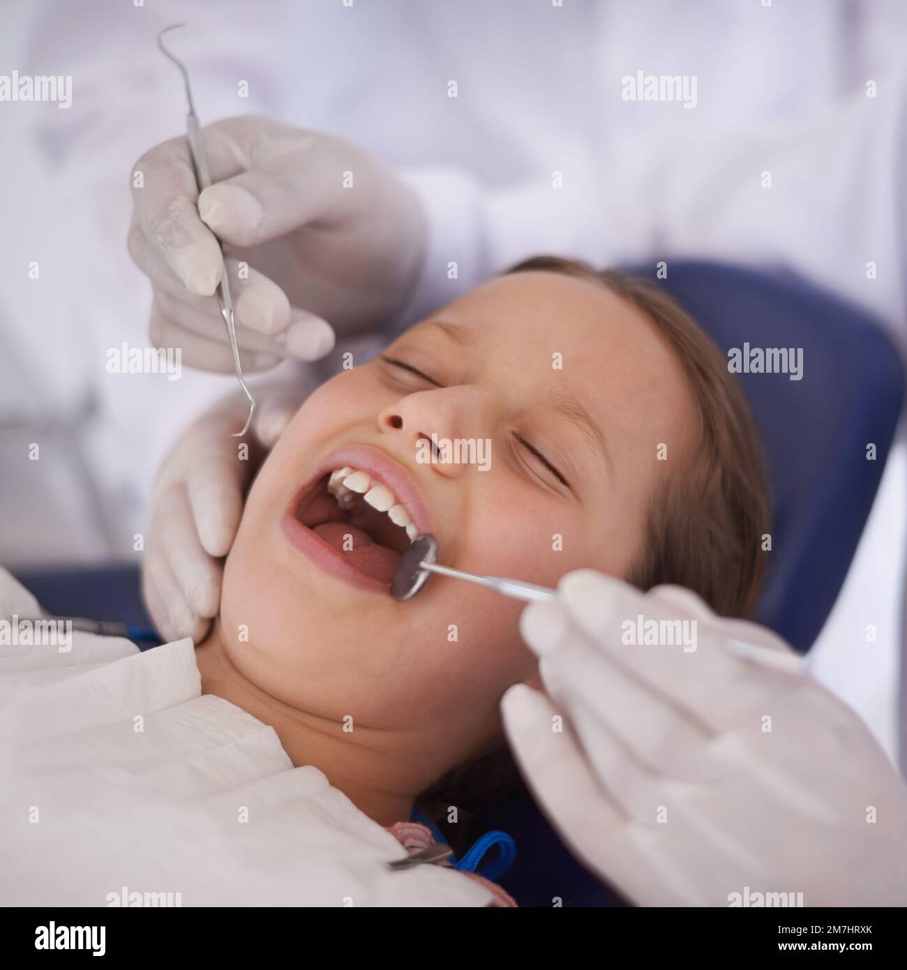 Tout semble en ordre. Un dentiste effectuant un examen dentaire d'une petite fille dents. Banque D'Images