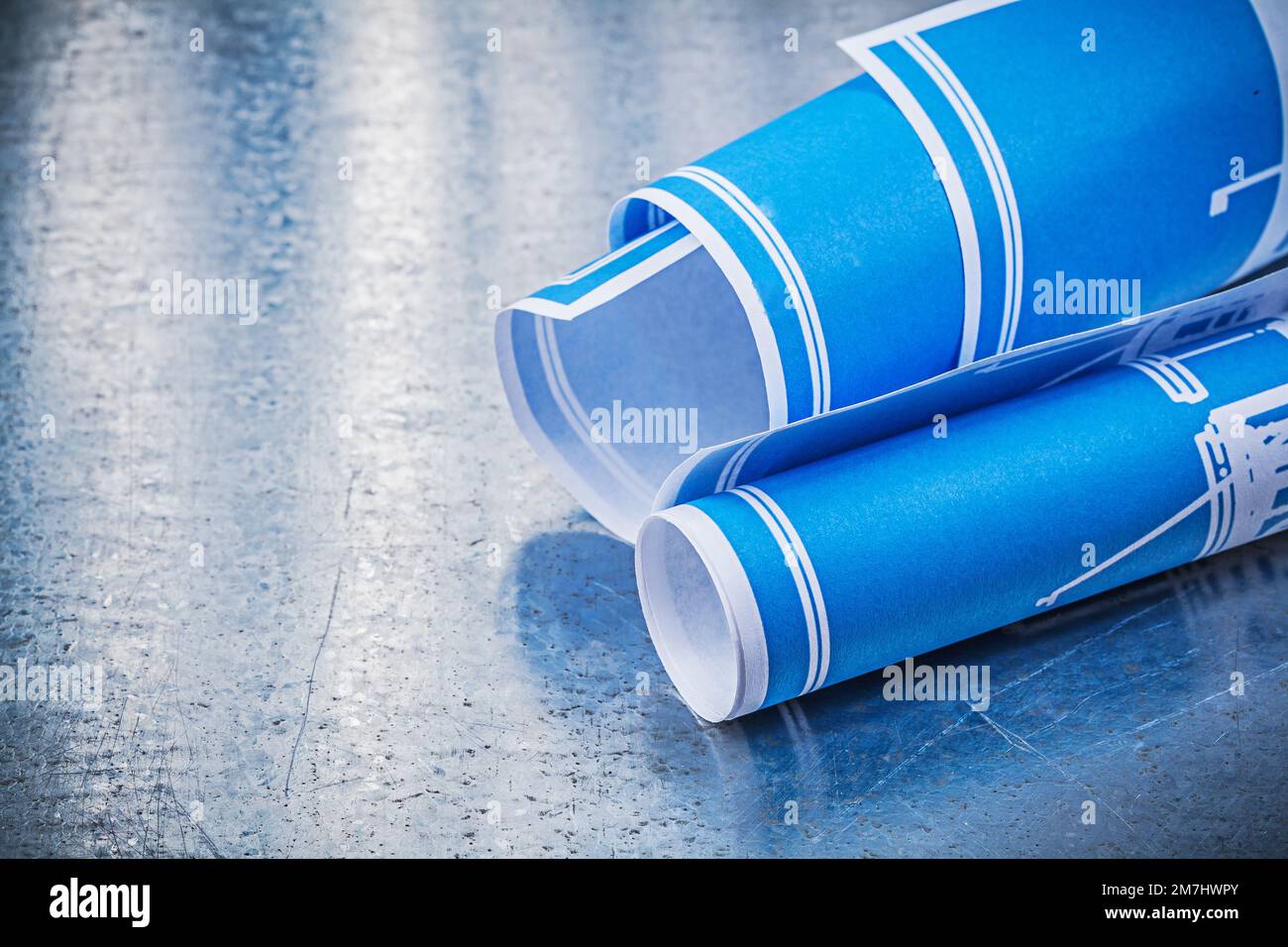 Concept de construction bleu roulé sur fond métallique rayé. Banque D'Images