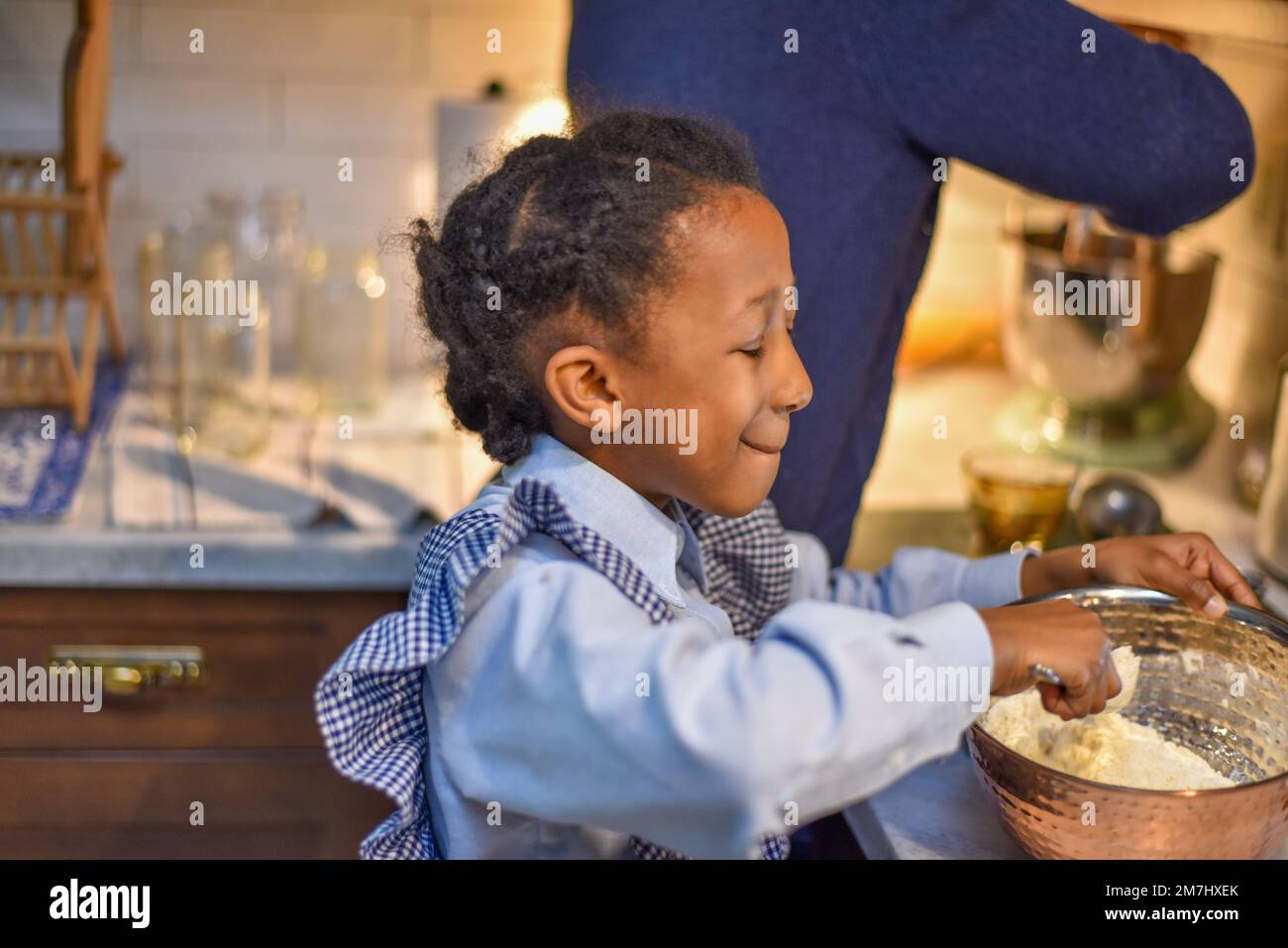 Petite fille aidant sa mère avec des vacances de Noël cuisson . Banque D'Images