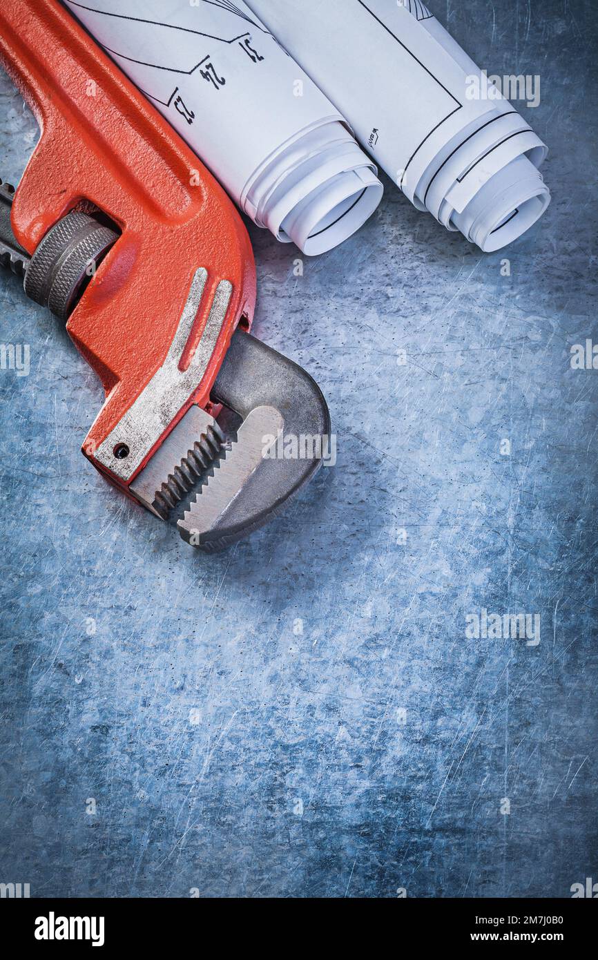 La clé à tube a enroulé les dessins techniques sur le concept de plomberie à fond métallique. Banque D'Images