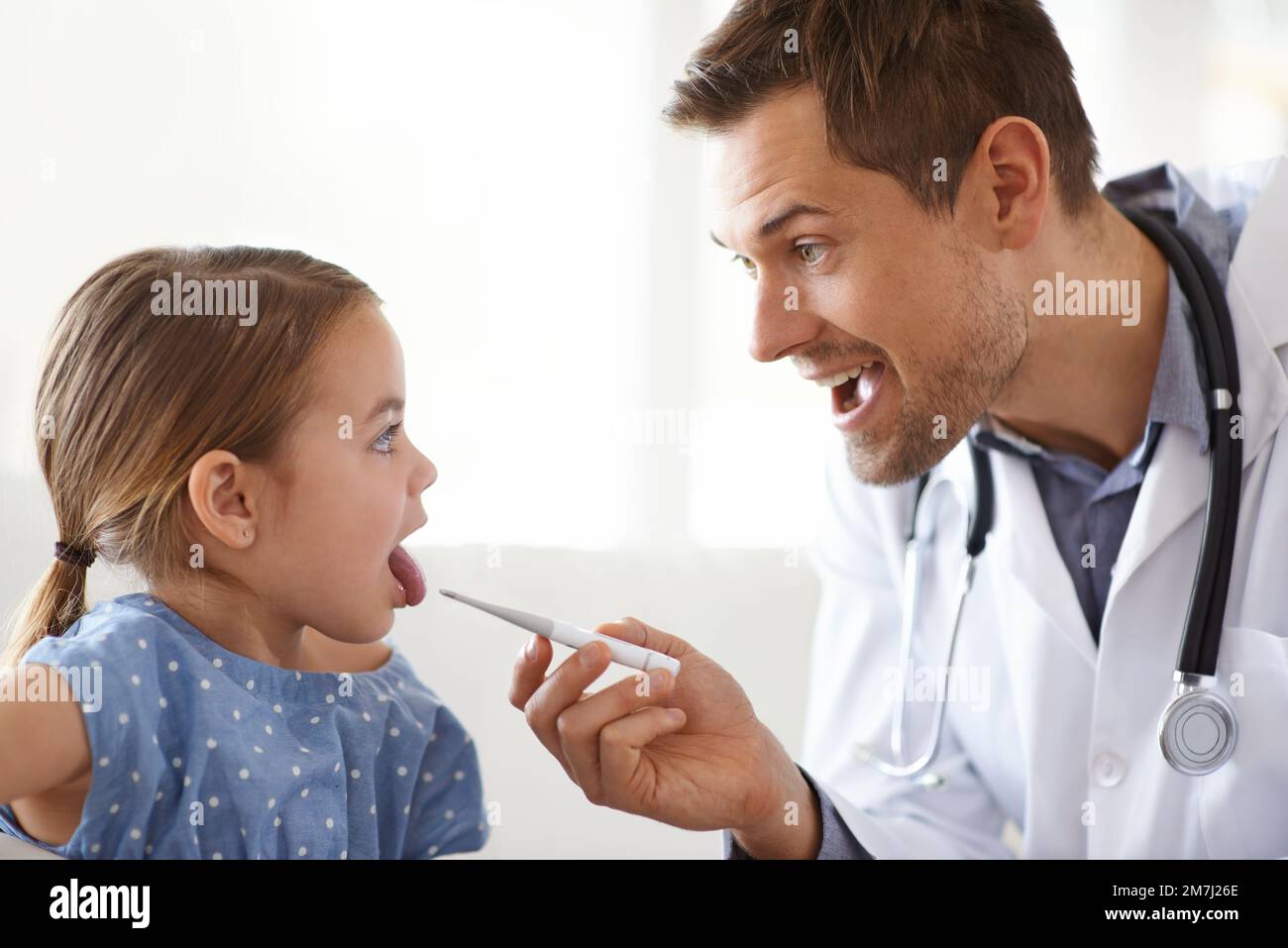 Dites aaah. une adorable jeune fille avec son pédiatre. Banque D'Images