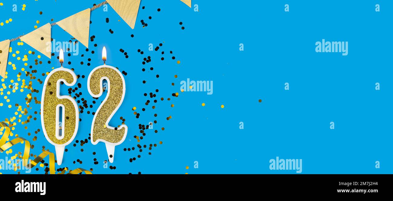 Bougie dorée numéro soixante-deux. Carte d'anniversaire avec inscription 62 sur fond bleu. Célébration d'anniversaire. Bannière. Banque D'Images
