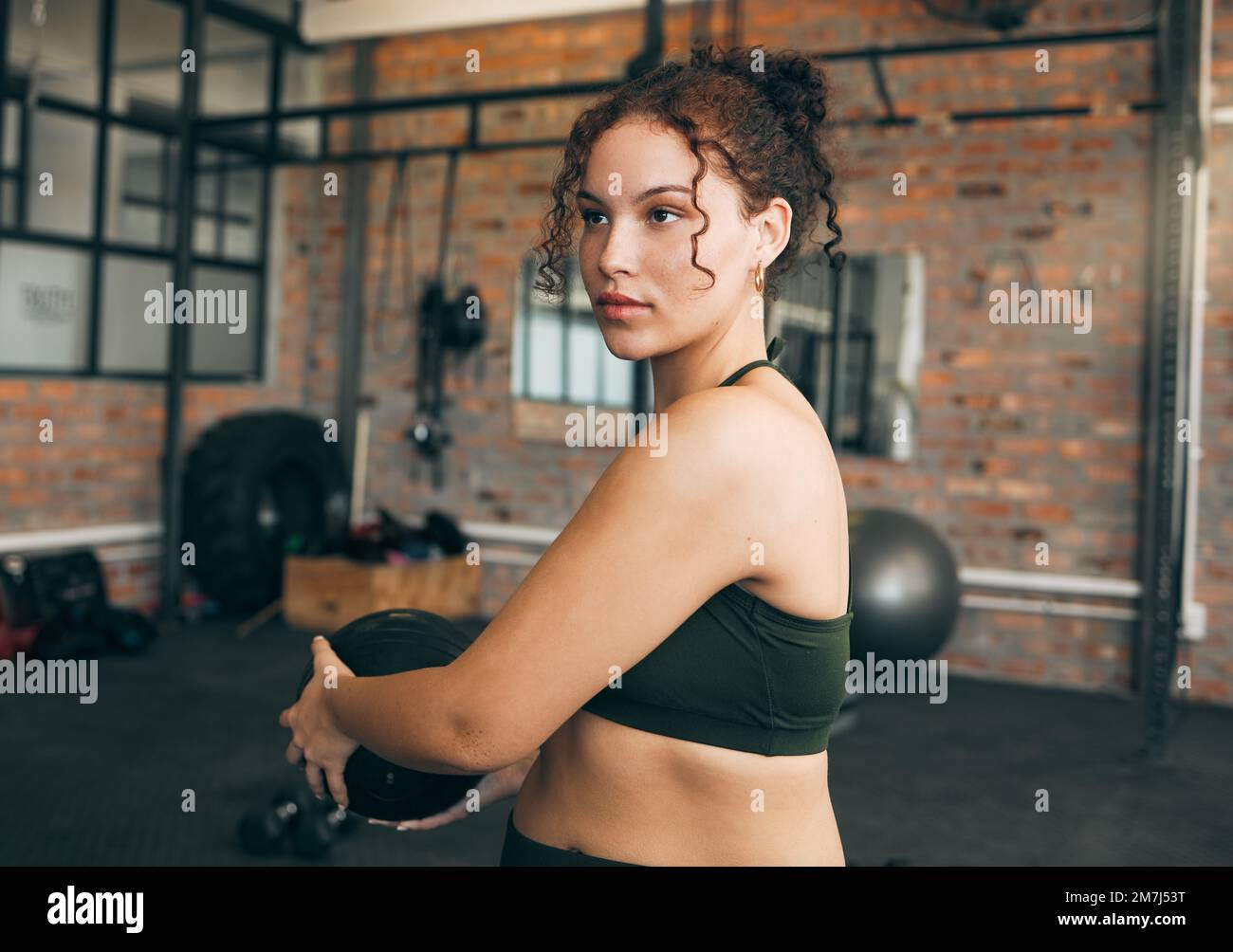 Exercice, ballon de médecine et une femme forte à la salle de gym pour une séance d'entraînement, de fitness et de bien-être du corps. Sport féminin ou athlète avec concentration pendant le poids Banque D'Images