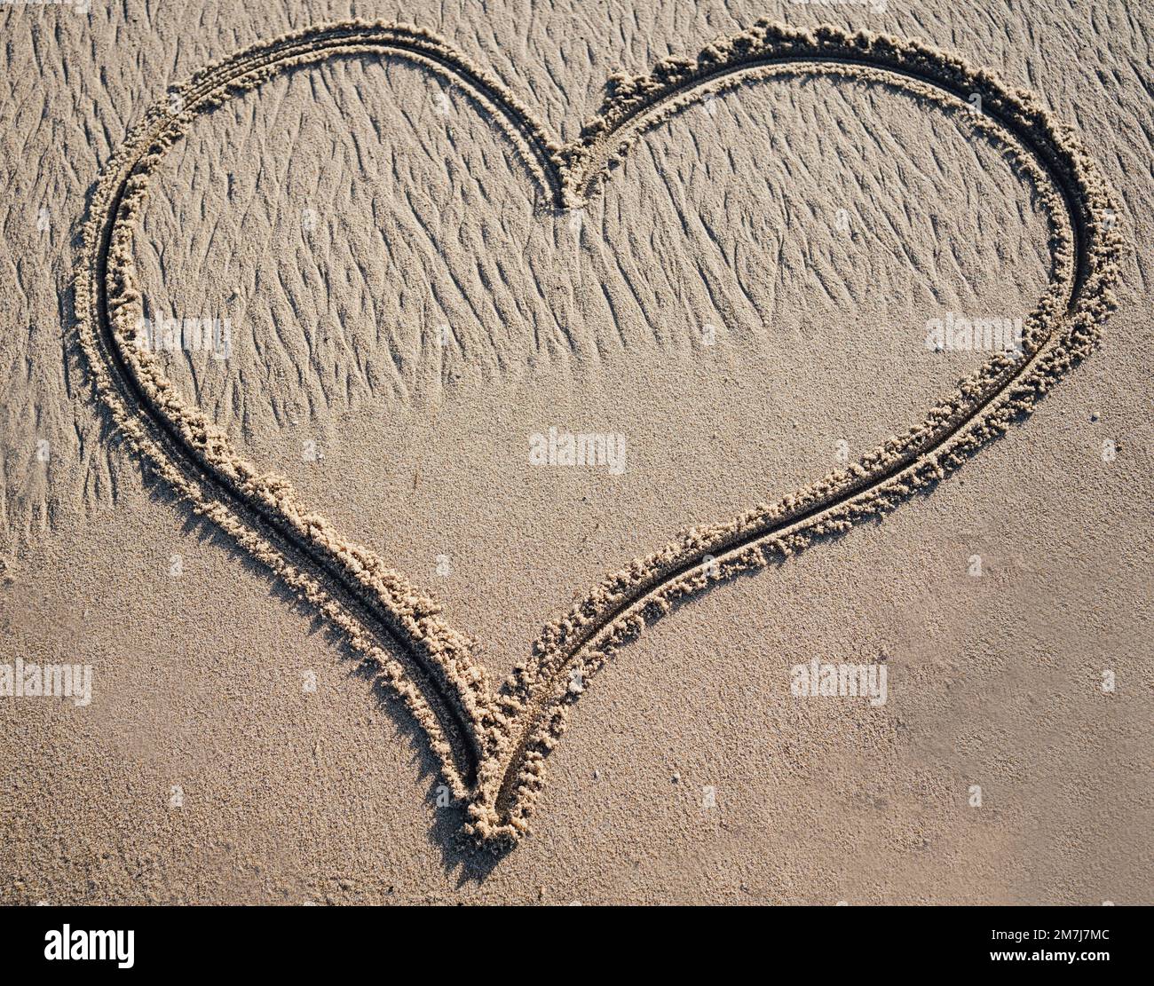 Un grand coeur dessiné dans le sable avec l'espace de copie Banque D'Images