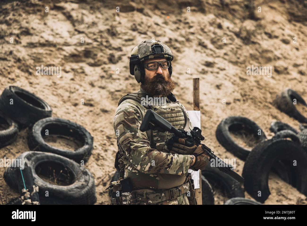 Soldat mûr debout près de la cible de tir avec le fusil dans les mains Banque D'Images