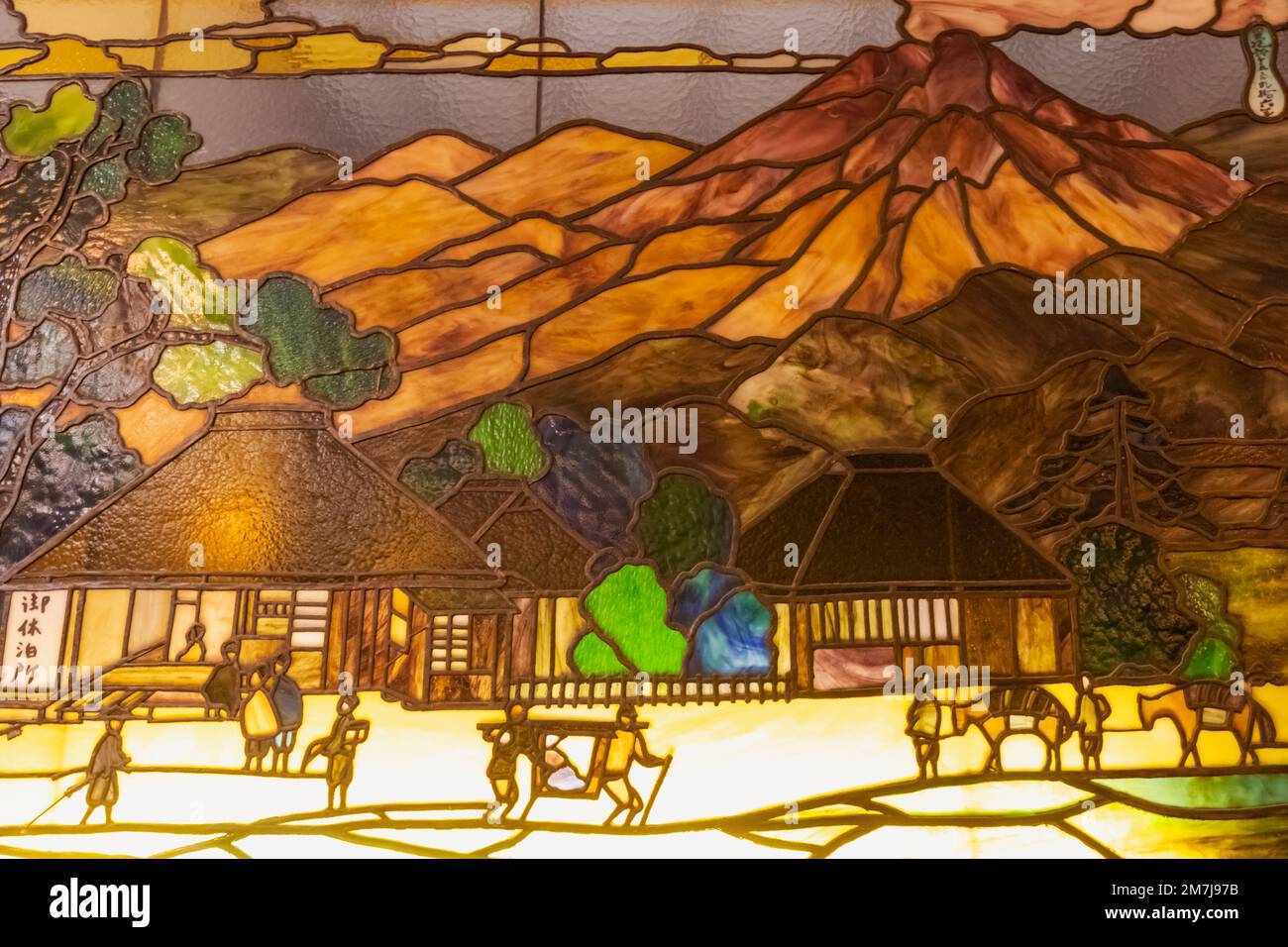 Japon, Honshu, Préfecture de Nagano, Karuizawa, Hôtel historique de Mampei, Fenêtre en vitraux du hall représentant une scène historique avec des voyageurs et des Moun Banque D'Images