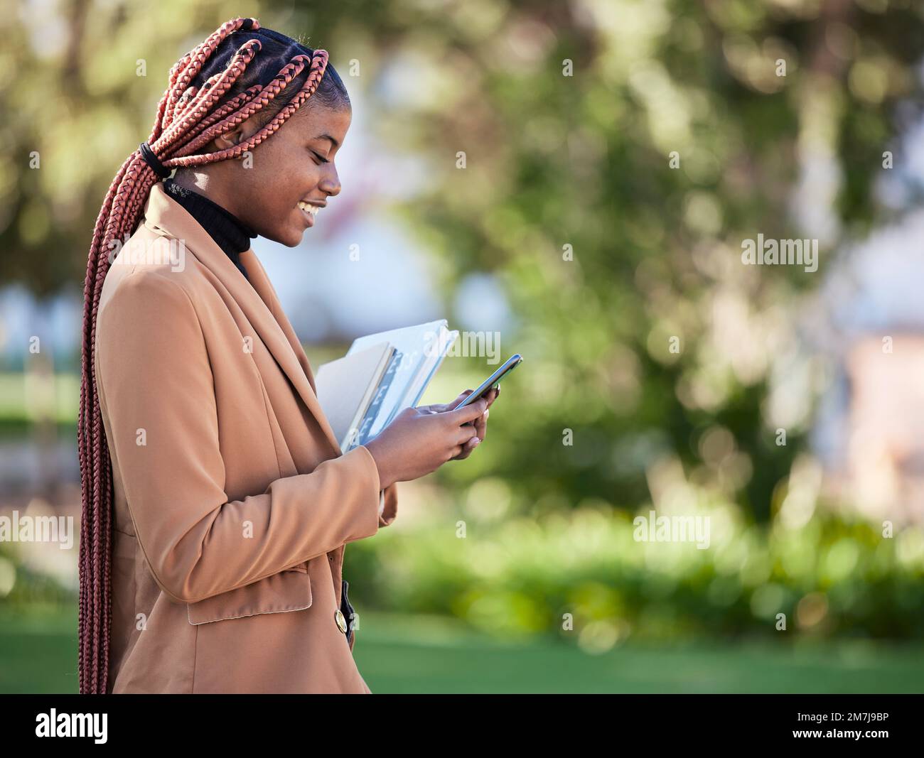 Téléphone, étudiant en bourse et femme noire au parc sur les médias sociaux, la recherche ou l'envoi de SMS. Technologie, éducation et femme heureuse avec des livres sur 5g Banque D'Images