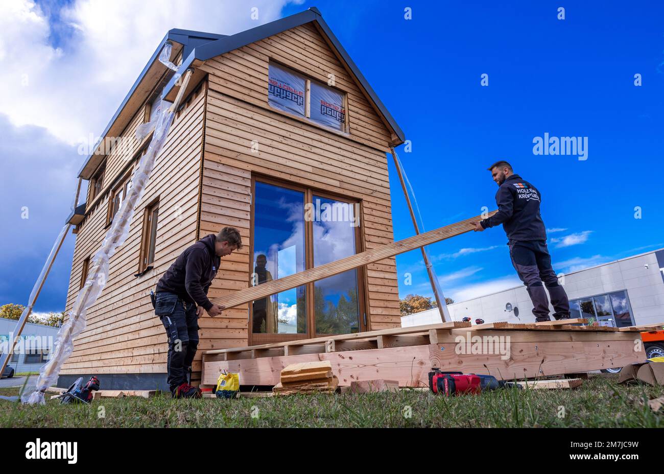 PRODUCTION - 19 septembre 2022, Mecklembourg-Poméranie occidentale, Brüsewitz: Tom Hinze (l) et Stefan Kröplin (r) construisent la terrasse de la première petite maison de spectacle. Il a été construit et fabriqué dans un magasin de menuiserie à Upahl depuis mars 2022. La maison écologiquement construite a une façade en mélèze sibérien et des fenêtres faites à la main en bois de chêne. La maison, qui mesure 3,30 mètres de large et sept mètres de long, a une hauteur de crête de cinq mètres et offre 30 mètres carrés d'espace de vie sur deux étages. S'il y a suffisamment d'intérêt pour le client, jusqu'à dix maisons par an doivent être fabriquées en t Banque D'Images