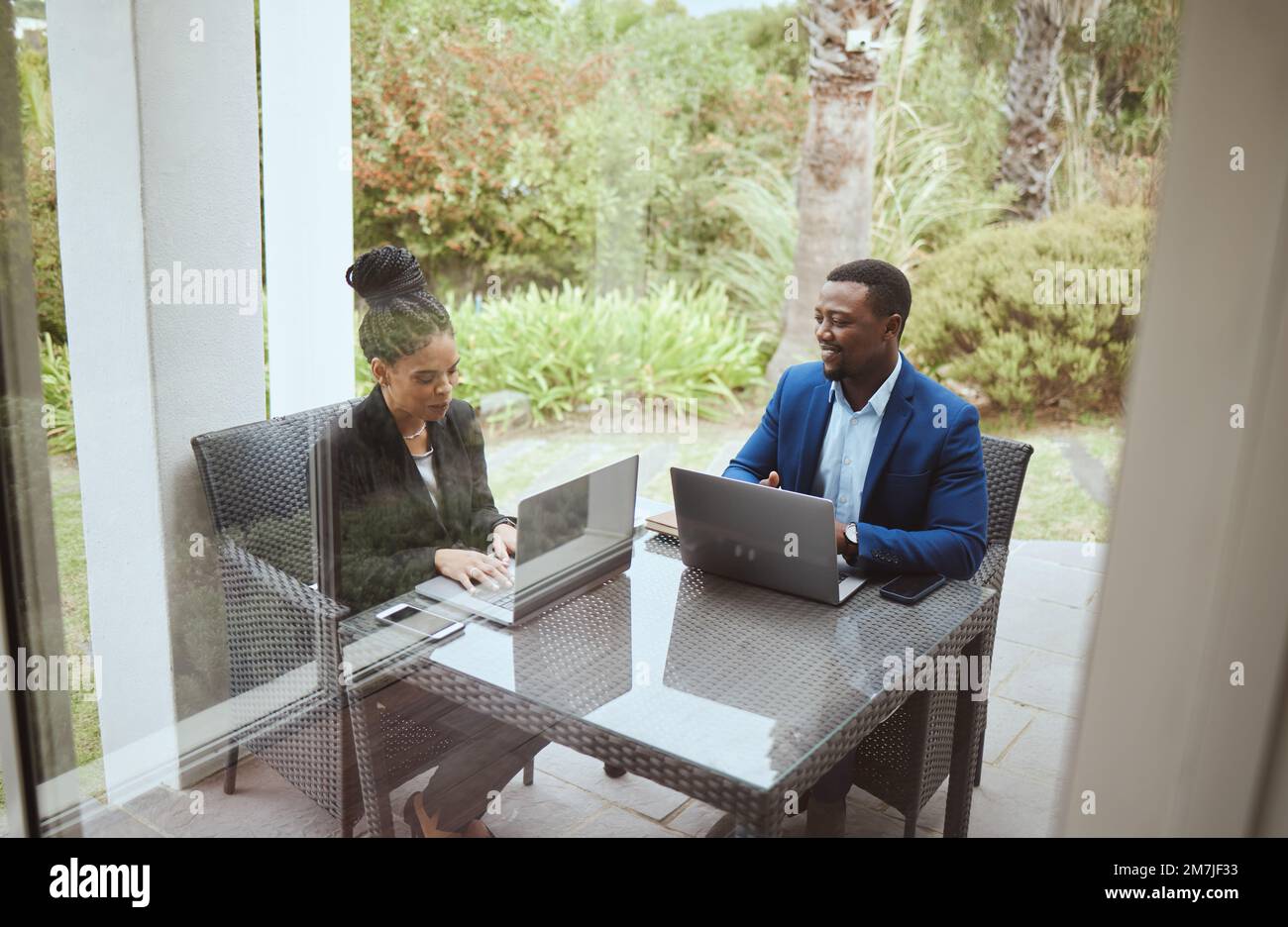 Hommes d'affaires, hommes et femmes noires en réunion sur terrasse, ordinateur portable et objectif financier en voyage d'affaires. Homme noir, femme et travail d'équipe le matin Banque D'Images