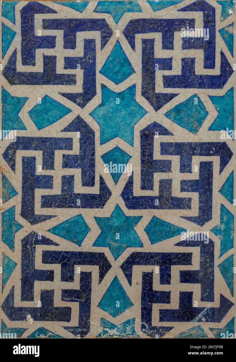Carrelage décoratif en céramique bleu, blanc et turquoise antique avec motif svastika et étoile sur le tombeau médiéval, UCH Sharif, Bahawalpur, Punjab, Pakistan Banque D'Images
