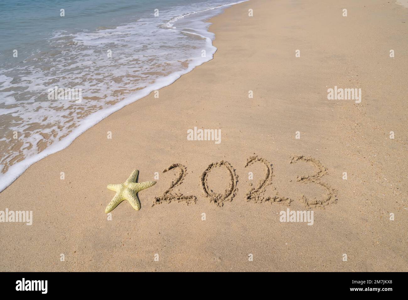 2023 écrit à la main avec des étoiles de mer dans le sable sur une belle plage Banque D'Images