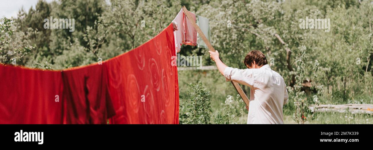 jeune corbeau mûr et candié, il fait ses devoirs et pendre la buanderie pour sécher sur une corde à linge dans la rue dans la cour du cottage de ménage du village Banque D'Images