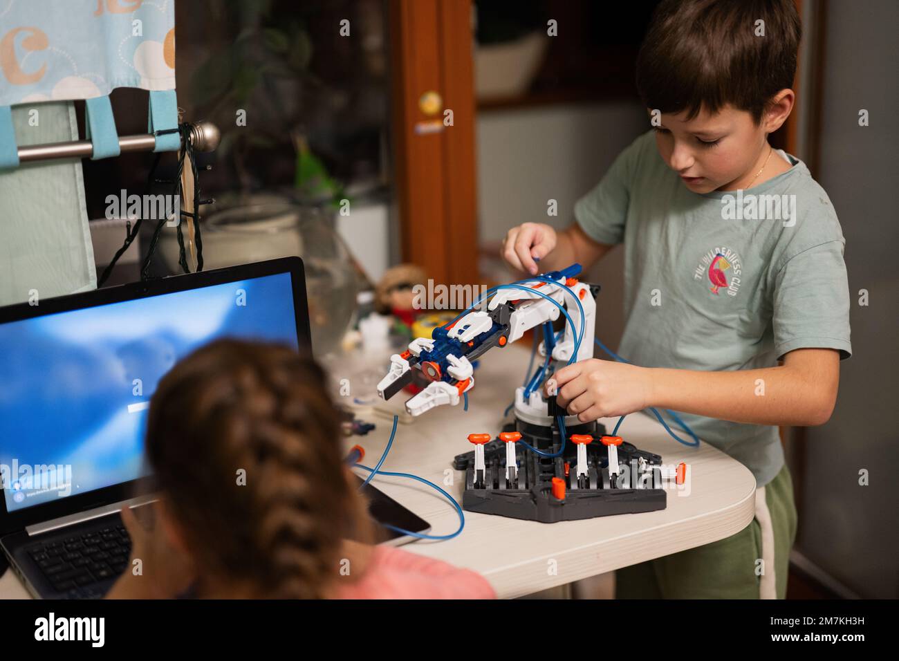 Les enfants apprennent à réparer le bras robot de commande de leçon, le bras de machine robotique dans l'atelier à domicile, la technologie future éducation scientifique. Banque D'Images