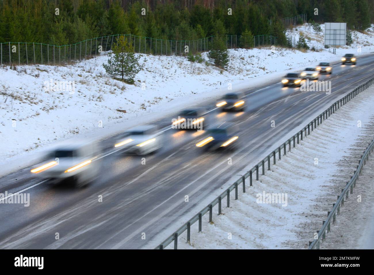 Voitures à grande vitesse sur l'autoroute en un jour d'hiver, flou de mouvement à l'intérieur de l'appareil photo. Banque D'Images