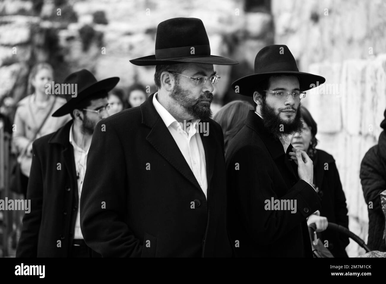 Une photo en noir et blanc d'hommes portant des chapeaux noirs a été prise lors de la promenade photo de la rue à Jérusalem, en Israël Banque D'Images