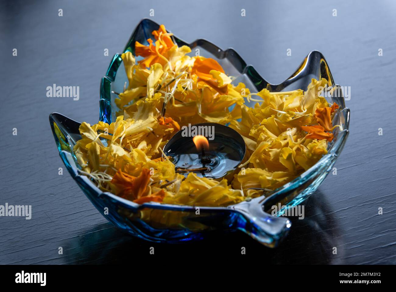 Bougie avec pétales de fleur dans un bol en verre en forme de feuille photo pour la décoration de la maison Banque D'Images