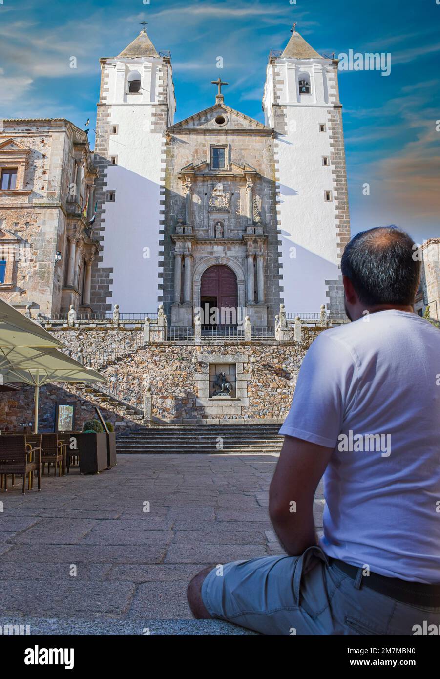 Homme adulte sur son dos observant la belle façade de l'église de San Francisco y Javier à Cáceres, Espagne Banque D'Images