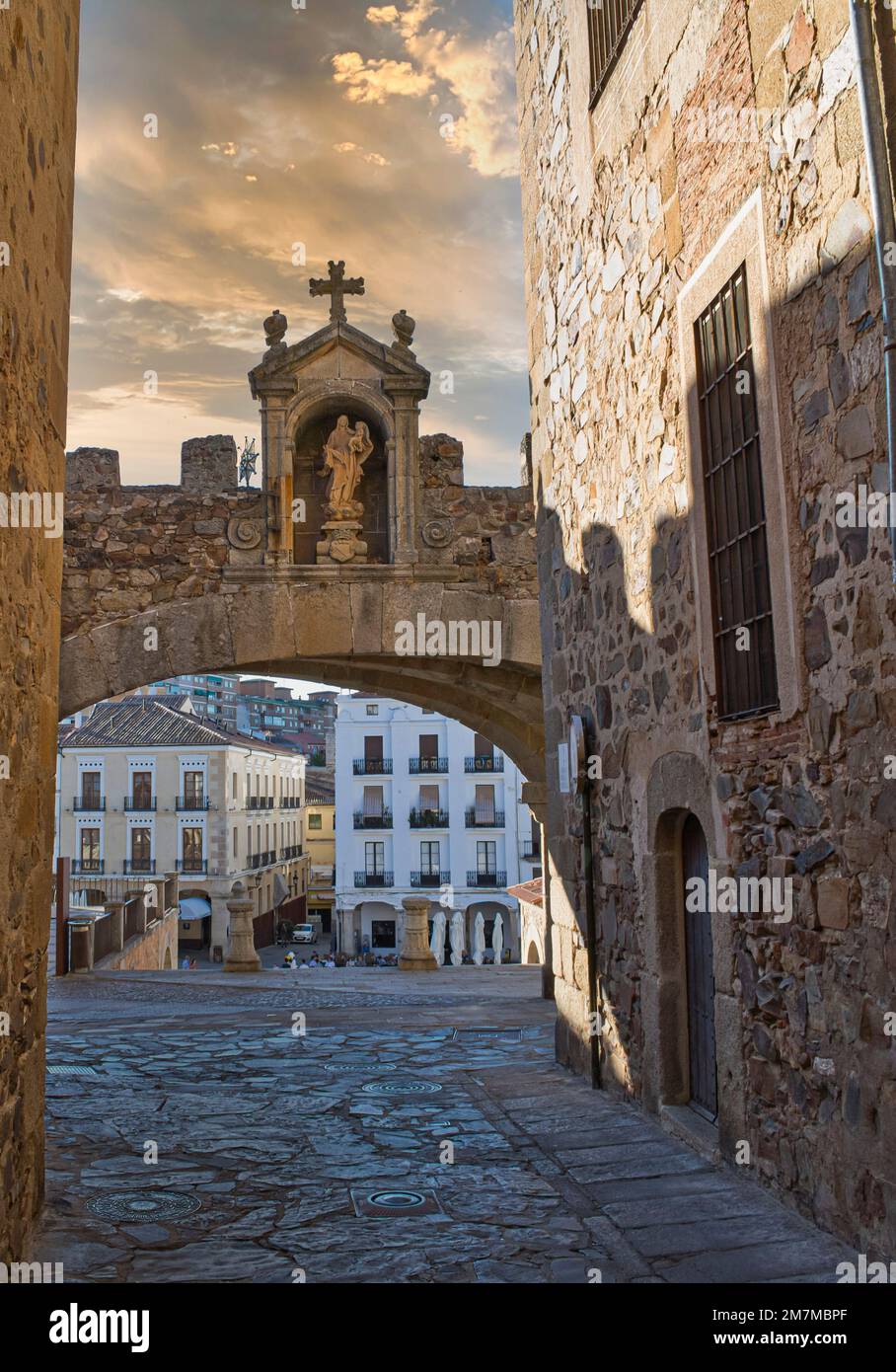 Étroite rue pavée avec l'arche de l'étoile et vue sur la place principale de Cáceres, Espagne Banque D'Images