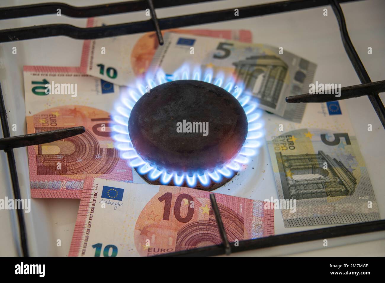 Les billets de banque se trouvent sous la flamme d'un poêle à gaz. Banque D'Images