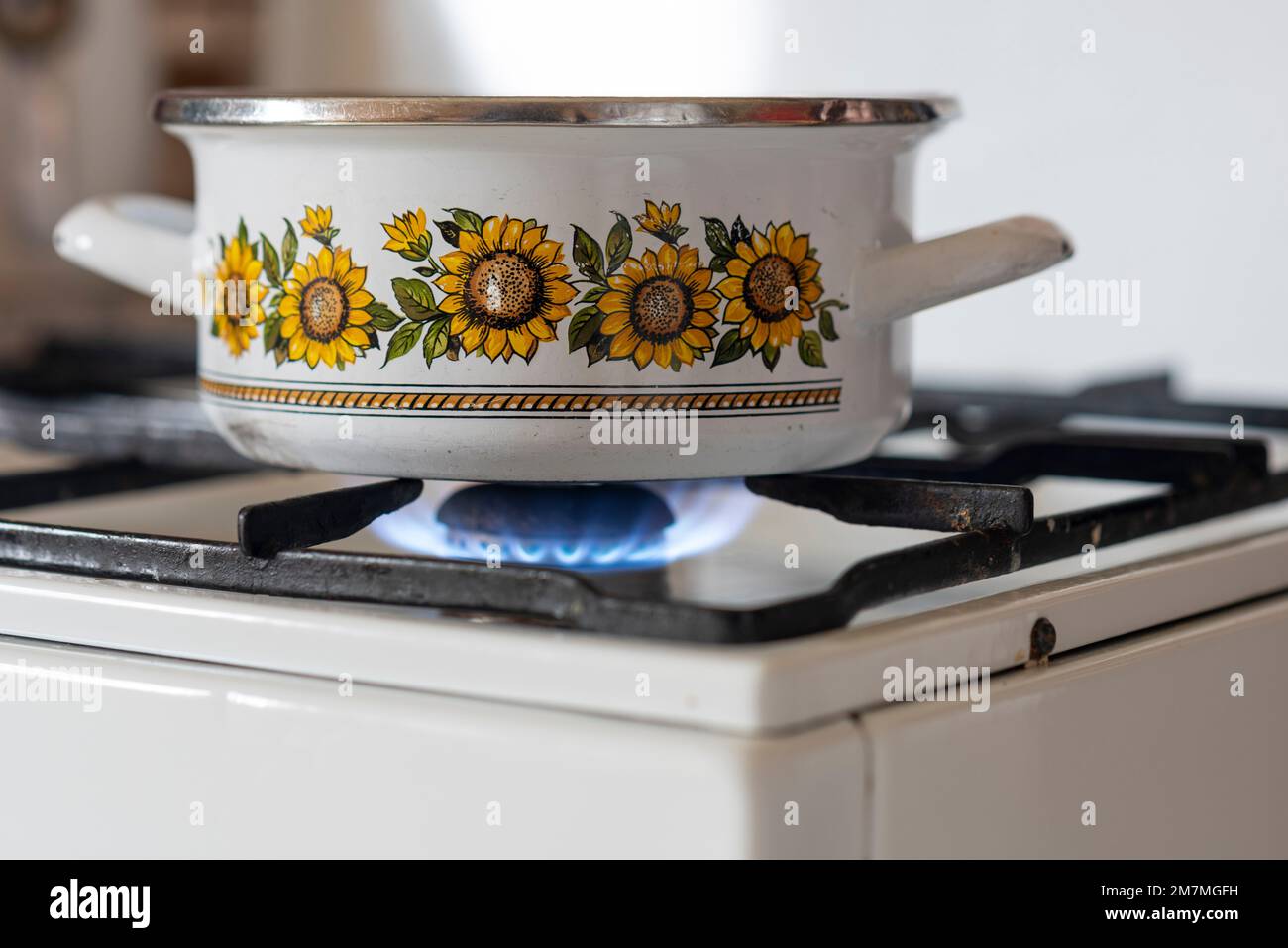 La flamme d'un vieux poêle à gaz brûle dans une cuisine. Banque D'Images