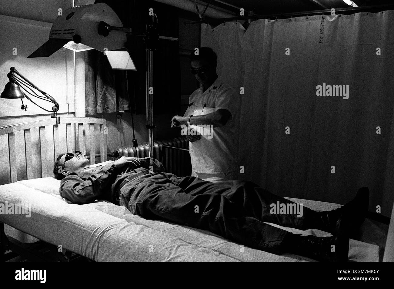 TSGT Lester Dollar, technicien en physiothérapie, administre un traitement de l'acné ultraviolette à A1c Forrest E. Morgan à l'hôpital USAF. Base: Base navale aérienne, Misawa État: Aomori pays: Japon (JPN) Banque D'Images