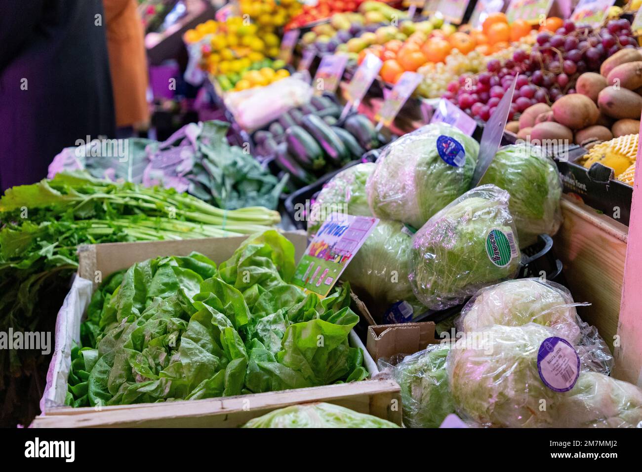 Lettres. Une cale de fruits et légumes. Décrochage de laitue dans un marché de Madrid, Espagne. Feuilles de laitue verte avec gouttes d'eau. Photographie horizontale. Banque D'Images