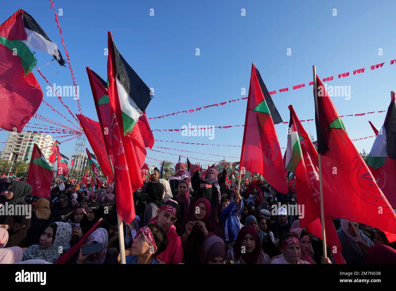 Women activists from the Popular Front for the Liberation of Palestine (PFLP) wave their national and party's red flags while marking the 55th anniversary of the PFLP at Al Kateba Square in Gaza City, Thursday, Dec. 8, 2022. Founded in 1967, the PFLP is a Marxist-Leninist, nationalist, political and militant organization. (AP Photo/Adel Hana) Banque D'Images