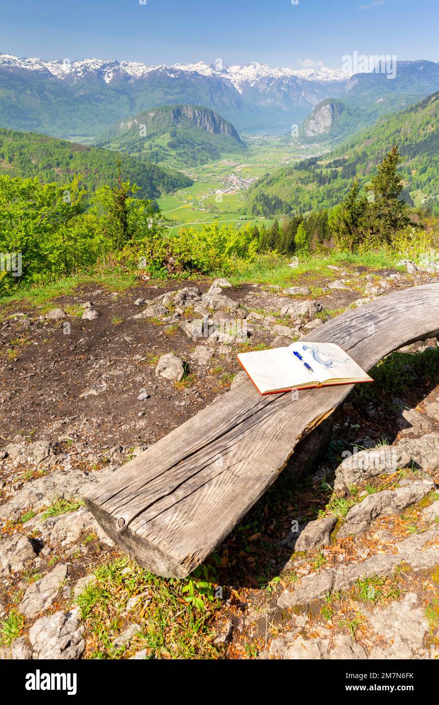 Un banc en bois et un registre de trekking en face du point de vue de Vodnikov avec vue sur le lac et la vallée de Bohinj. Bohinjska Bistrica, Slovénie, Europe. Banque D'Images