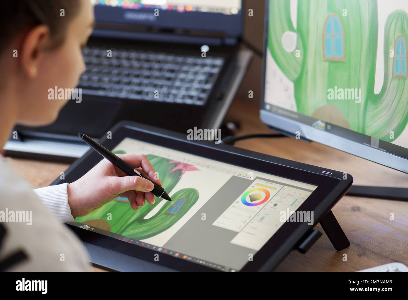 Vue rapprochée d'une fille qui dessine sur une tablette numérique. Jeune fille travaillant à la maison en tant que graphiste. Jeune femme qui dessine sur une planche à dessin numérique. Banque D'Images