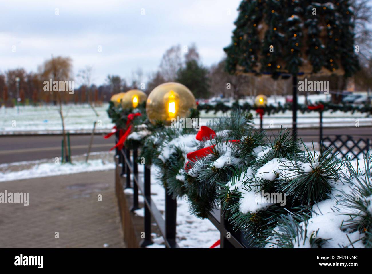 Décoration de Noël faite de branches d'épicéa dans la ville pour les vacances d'hiver. L'entrée du magasin est décorée de lanternes et Banque D'Images