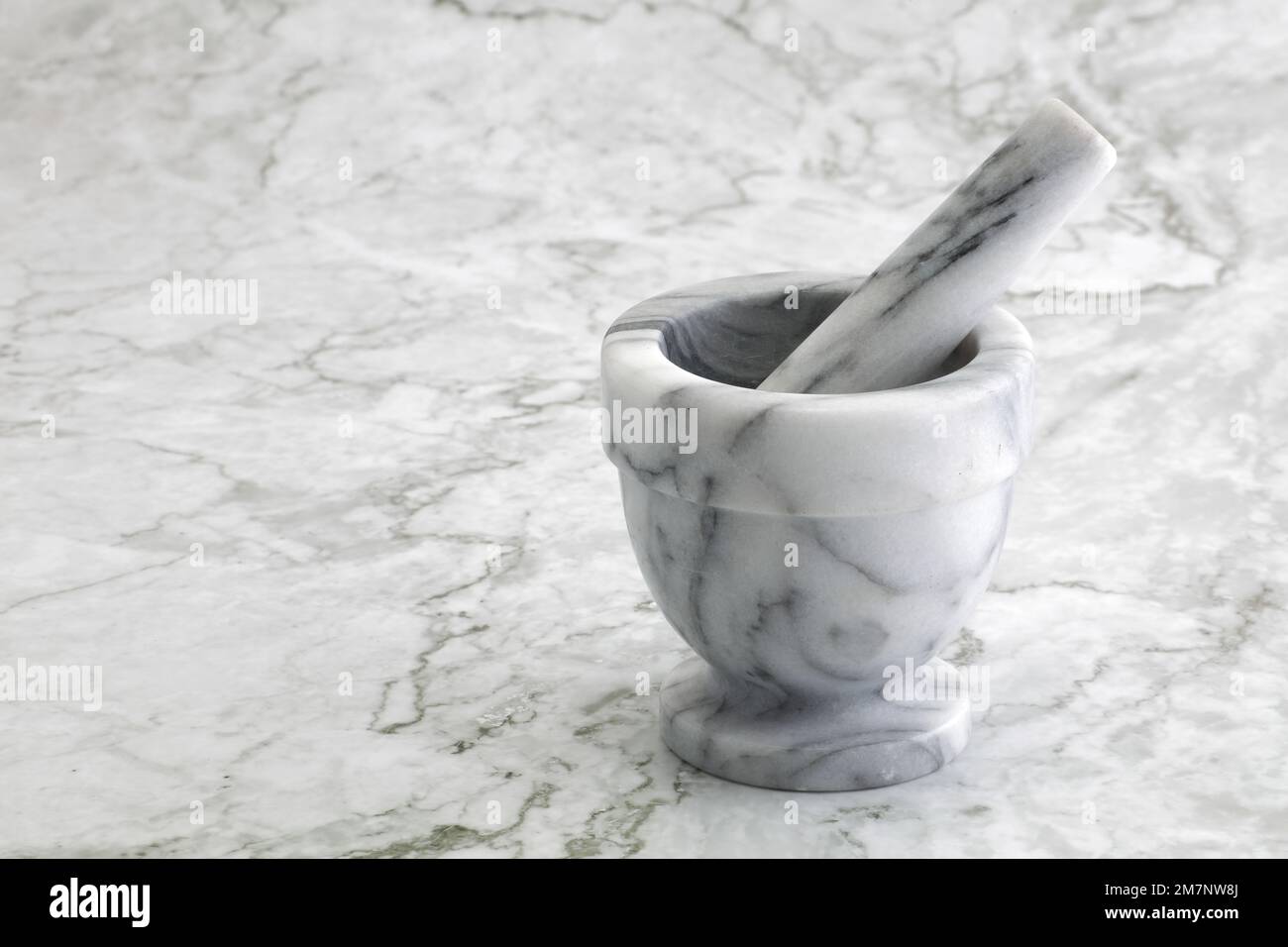 Mortier et pilon sur une surface de cuisine en marbre Banque D'Images